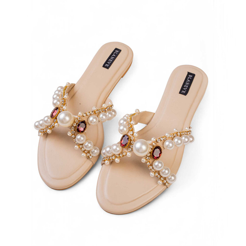 Angled view of BLANEVE Reina cream slides with graduated pearls, rhinestones and oval gem accents