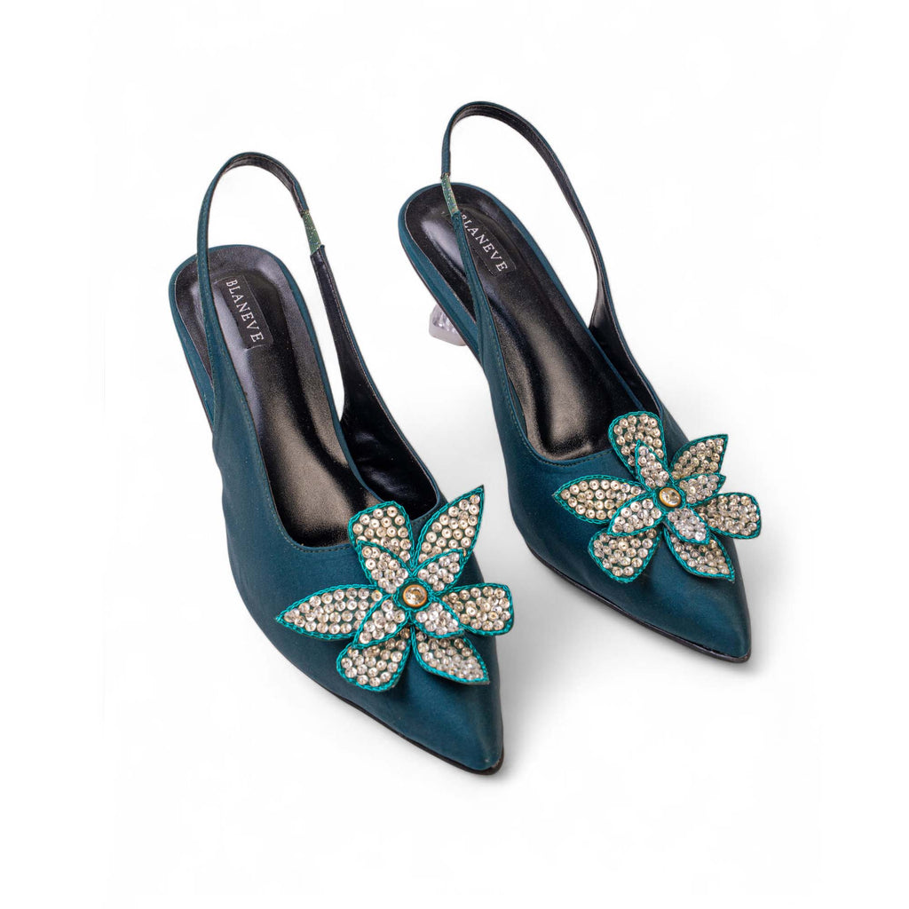 Angled view of BLANEVE Lagoon deep teal heels showing embellished flowers and slim slingback straps.
