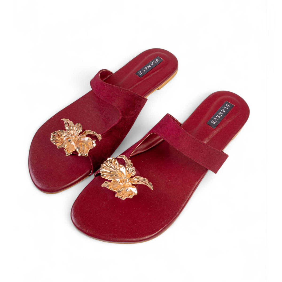 Angled view of BLANEVE Merlot maroon toe-post sandals with gold-toned flower embellishments