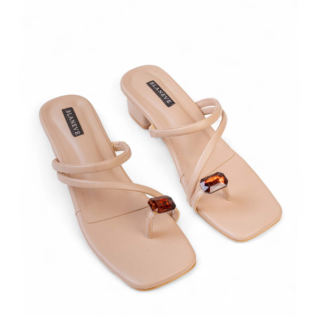 Pair of BLANEVE Willow beige square-toe sandals with crisscross straps and amber-toned stone embellishments.