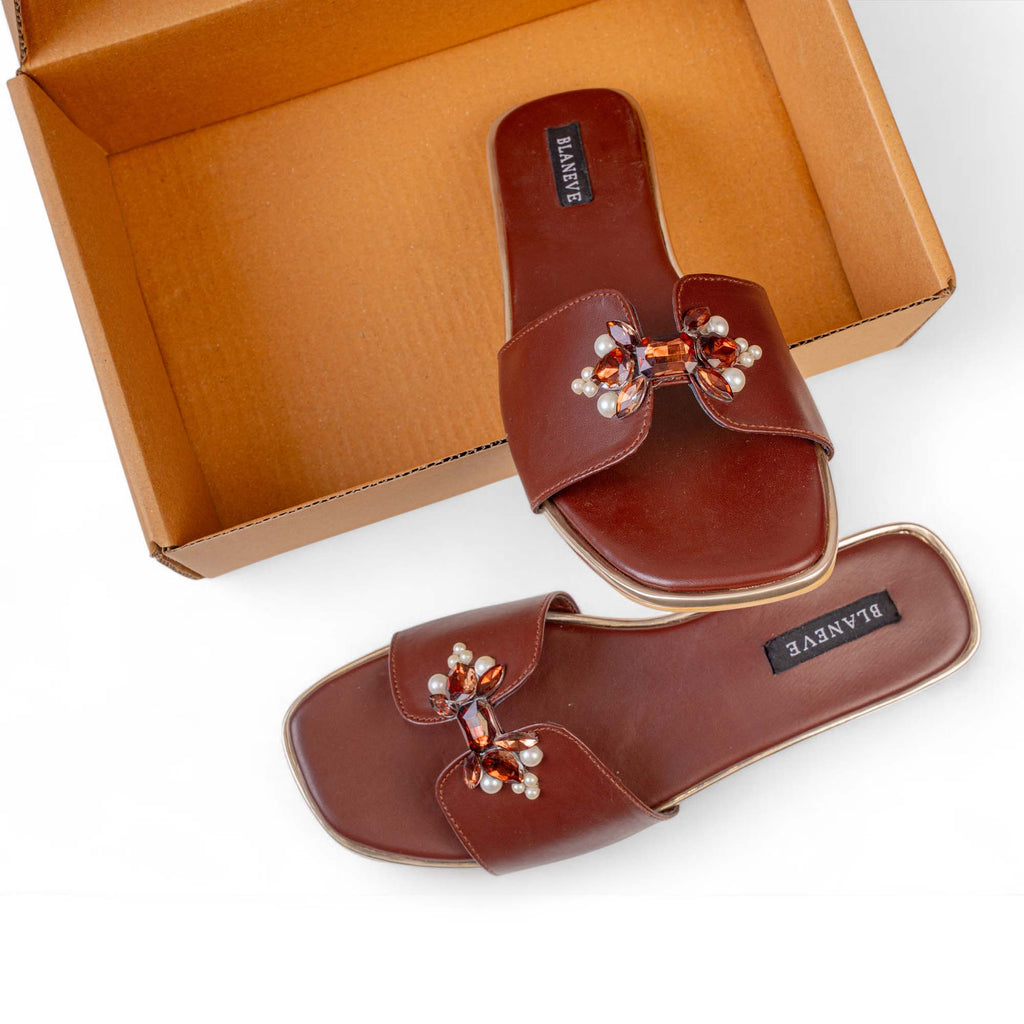 BLANEVE Cove brown slides with pearl and amber-toned details displayed beside an open shoe box